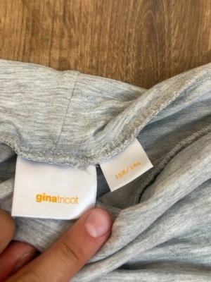 Grå ribbade leggings från Gina Tricot - Snygga ljusgrå leggings från Gina Tricot med ribbad struktur och utsvängda ben. Mjukt och stretchigt material som sitter skönt på kroppen. Perfekta till en avslappnad look och passar till både sneakers och boots. Knappast andända och inga defekter alls 