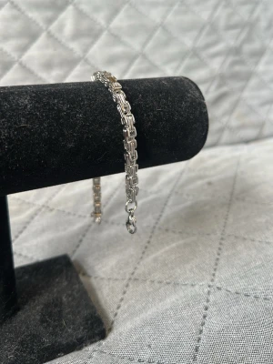 Silverfärgat kedjearmband - Stilrent armband i silverfärg med robust kedjedesign. Armbandet har en klassisk karbinhake och länkar med fyrkantig form som ger en modern och clean look. Perfekt för dig som gillar minimalistiska accessoarer i stål. 20cm. Checka in min profil för passande halsband.