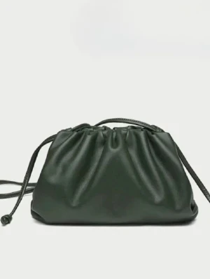 Mörkgrön clutch i fejkläder - Trendig mörkgrön handväska i mjukt fejkläder med dragskostängning och slät yta. Väskan har en puffig form och smala axelband som ger en modern look. Perfekt för dig som vill ha en stilren accessoar med det lilla extra.