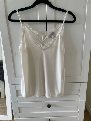 Vit spetstopp  - Säljer denna vita spets topp från H&M i storlek S. Tröjan är knappast använd och är i mycket fint skick.❤️