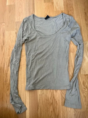 Khaki långärmad topp med rund hals - Säljer en enkel och stilren  långärmad topp med rundad halsringning och slits vid ärmarna. Från Gina Tricot. Användes max 1 gång. För liten för mig därför säljer jag den🖤
