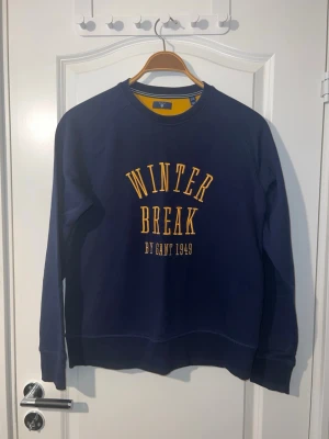 Gant långärmad tröja  - Säljer en mörkblå sweatshirt från GANT i väldigt fint skick. Stilren och bekväm modell med broderad text framtill som ger en snygg detalj. Tröjan är sparsamt använd utan fläckar eller skador och passar perfekt till vardag. Finns att hämta i Södertälje.
