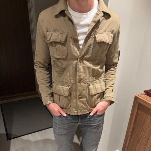 Vår jacka - Fet jacka med unika detaljer. Detaljerna på denna jackan är riktigt snyggt och har de har en sliten stil på sig som gör jackan mer casual och unik! Osäker på att göra mig av med den men kommer inte till så mycket användning och vill göra intressekoll på denna! Sitter som S/M. 