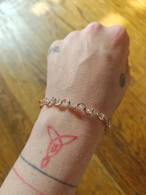 Armband i ren koppar och glaspärlor  - Snyggt armband i ren koppar med vågig design och glas pärlor. Armbandet har en modern och stilren look som passar perfekt till din outfit. Pärlorna är infattade i metallen och ger ett elegant intryck.