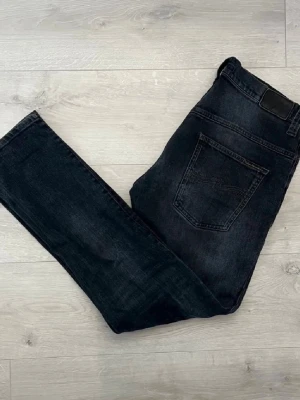Svarta nudie jeans - Säljer ett par svarta jeans från Nudie Jeans i slim fit. Riktigt clean modell som sitter snyggt och passar till allt.  • Färg: Svart • Fit: Slim fit • Skick: Bra skick • Stretchiga och bekväma • Enkel att styla till både vardag och finare outfits • Tidlös modell som aldrig går fel