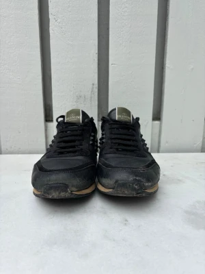 Valentino rockrunners - Snygga Valentino rockrunners med mattsvarta nitar på sidorna och detaljer i mocka och läder. Skorna har svart snörning och en kontrasterande beige sula. Perfekta för dig som gillar en stilren men edgy look. Har förmodligen en box. Har kvitto, pris kan diskuteras 