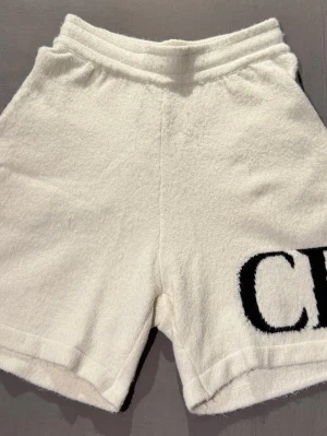 Cole Buxton shorts  - Säljer ett par mjuka och tjocka vita shorts från Cole Buxton med elastisk midja och två bakfickor. På ena benet finns en stor broderad svart logga med bokstäverna CB. Perfekta för chill dagar eller strandhäng. Riktigt bekväma. Storlek: M. Försiktigt använda. Skriv om du har några frågor! 