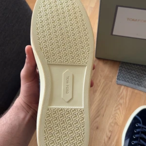 Mörkblå sneakers från nytt skick Tom Ford - Hej säljer mina mörkblå sneakers från Tom Ford med mocka krokodil effekt och kalvskinn. Säljer dessa för dem är inte min stil tycker att dem är inte fina på mig och använd skorna bara jag va utomlands en gång men har allmänt varit omtålig med dem. Medföljer box och dustbag och extra snörret ingick med har dem på skorna. Vänligen hör av er vid frågor eller funderingar absolut säg till