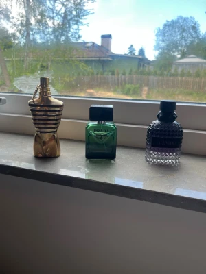 Valentino parfym med nitar och lila ton - Säljer en Valentino parfym i en cool, nitmönstrad glasflaska med svart lock. Flaskan har en snygg lila ton i botten som övergår till transparent upptill. Märket syns tydligt på etiketten framtill. Perfekt för dig som gillar exklusiva dofter. Jean Paulen är nästan slut ba få sprut kvar alla är i top skick.