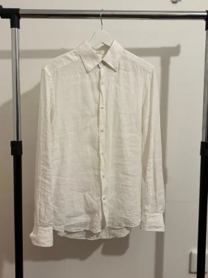 Vit linneskjorta från these glory days - Stilren vit skjorta i linne med klassisk krage och knappar framtill. Den är sparsamt använd och är i mycket bra skick.
