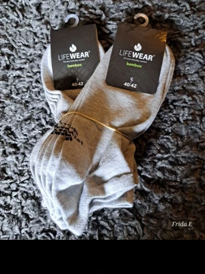 Gråa bambustrumpor LifeWear 40-42 - Säljer ett flerpack gråa strumpor från LifeWear i storlek 40-42. Tillverkade i mjukt och skönt bambumaterial som andas bra. Perfekta för dig som vill ha bekväma och stilrena strumpor till vardags. Klassisk modell utan synliga mönster.