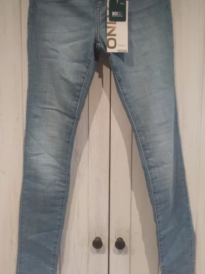 Ljusblå skinny jeans från ONLY - Säljer ett par ljusblå skinny jeans från ONLY, modell Anne K med mid waist. Jeansen har klassisk femficksdesign och är tillverkade i stretchigt denimtyg för en tight passform. Perfekta för dig som gillar en smal siluett och ljus tvätt.