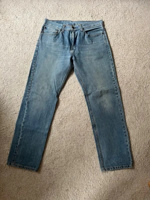 Levis 505 Jeans - Ett par ljusblå Levis 505 jeans med rak passform i storlek 32/32. Byxorna är i bra skick men är något slitna i skrevet, (Se bild). Skriv om du har några frågor. MVH Marcus