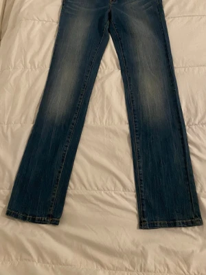 Blå bootcut jeans från Vero Moda. W28/L32.  - Säljer ett par blå bootcut jeans från Vero Moda med snygg slitning på låren och klassiska fem fickor. Jeansen har normalhög midja och är gjorda i ett mjukt denimtyg med lite stretch. Perfekta för en avslappnad och trendig look.