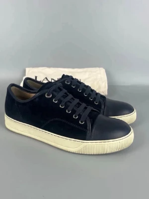 Blåa sneakers från Lanvin -  Stilrena blåa sneakers från Lanvin Klassisk låg modell med metallöljetter och diskret design som passar till det mesta. Storlek UK 6 vilket motsvarar 40/41. Pris kan diskuteras vid snabb affär. Vid behov av fler bilder så är det bara att skriva