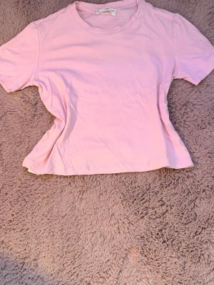Ljusrosa t-shirt från Mango - KÖPTE FÖR 200kr SÅ PASSA PÅ ATT KÖPA FÖR ETT OTROLIGT BRA PRIS 🏆 En basic ljusrosa t-shirt från mango med rund halsringning och korta ärmar. Tillverkad i mjuk bomull som känns skön mot huden. Perfekt att matcha med jeans eller kjol för en enkel och fräsch look.