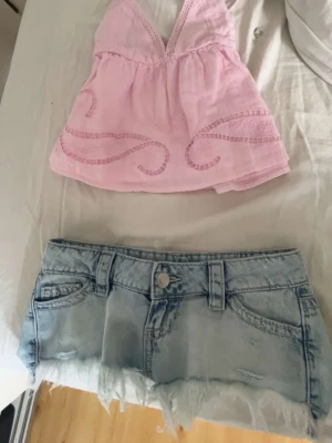 Ljusrosa broderad linnetopp Gina Tricot - Supersöt ljusrosa linnetopp från Gina Tricot med tunna axelband och v-ringning. Toppen har fina broderade detaljer framtill och är gjord i ett lätt och luftigt material, perfekt för varma dagar. Croppad modell med spetsdetaljer vid bysten.
