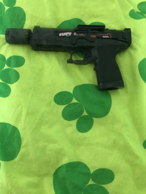 Svart leksakspistol SUPER - Jag säljer en elektrisk vattenpistol. Den kommer med pistol, laddare, batteri, sikte och en liten vattenburk som man häller i vatten för att pistol ska skjuta vatten