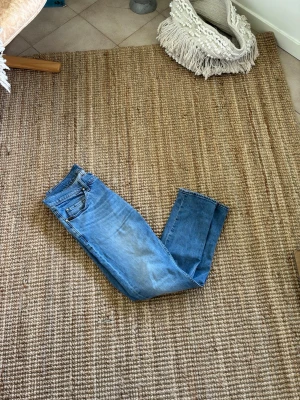 Ljusblå jeans med fades ifrån tiger of sweden - Säljer ett par ljusblå jeans från tiger of Sweden, de har snygga fades och passa perfekt inför sommarkvällarna när VM är igång