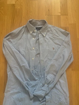 Ljusblå skjorta från Polo Ralph Lauren - Skjortan är från Raulph lauren men köpt på care of carl. Jag har ej använt den mer än 3 gånger då den är i storlek S slim fit och jag är 189 85kg cirka och den är ganska tajt i armarna och bröstet. Skjortan stryks vid köpet och är i väldigt bra skick. I princip ny..
