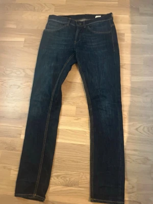 Mörkblå raka jeans med kontrastsömmar - Säljer ett par mörkblå jeans med raka ben och snygga kontrastsömmar. Klassisk femficksmodell och normal midja. Jeansen har en enkel, stilren look som passar till det mesta. Materialet är kraftig denim i bomull. Pris kan diskuteras.