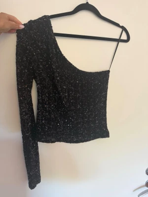 Svart glittrig oneshoulder topp - Svart glittrig oneshoulder topp från mango 
