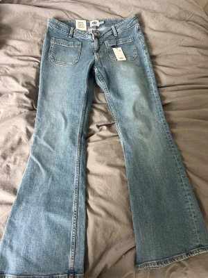 Bootcut jeans i ljusblå denim - Säljer ett par snygga bootcut jeans från 157 i ljusblå tvätt. Jeansen har klassiska fem fickor, bälteshällor och en låg midja. Materialet är mjuk denim som ger en avslappnad vibe. Perfekta för dig som gillar retrostilen och vill ha ett par jeans med schysst passform. Helt nya
