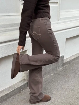 Bruna bootcut jeans med fickdetalj - Snygga bruna bootcut jeans med dekorativ söm på bakfickan. Från Nelly å helt nya, har prislappen å allt kvar 