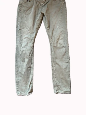 Ljusgröna jeans med detaljer - Säljer ett par ljusgröna jeans med raka ben och coola sömdetaljer framtill. Jeansen har klassiska fickor och dubbla knappar i midjan.    Det står XL men sitter som 38💚De e från please tror jag 