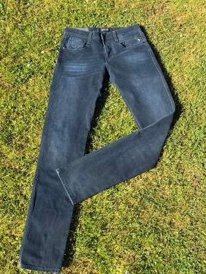 Mörkblå slim fit jeans Anbass w29/l34 - Snygga mörkblå slim fit jeans med klassiska fem fickor och raka ben. Jeansen har en stilren look och passar perfekt till en avslappnad streetstyle. Materialet är mjukt denim som ger en skön känsla hela dagen.