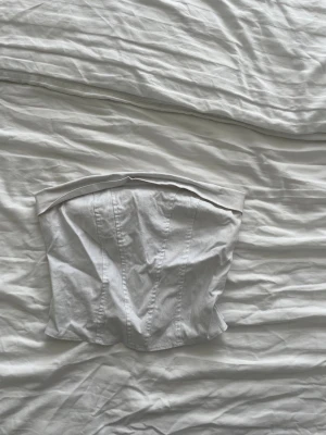 Vit tubtopp i korsettstil - Snygg vit tubtopp med korsettkänsla och markerade sömmar. 