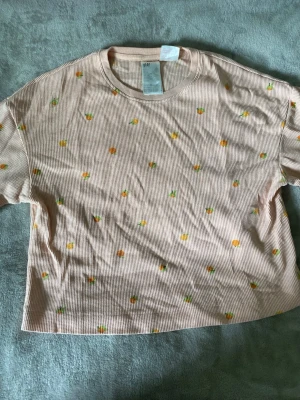 Pyjamas set - Persika färgat pyjamasset med persika eller apelsin motiv. Materialet är ribbat och tröjan är boxig och oversized.
