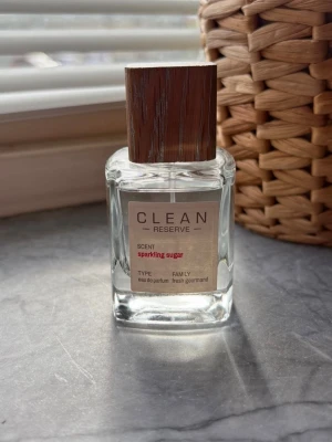 CLEAN Reserve Sparkling Sugar parfym - Fräsch parfym från CLEAN Reserve i doften Sparkling Sugar. Flaskan är genomskinlig med en stilren etikett och ett elegant lock i träimitation. Eau de parfum med en söt och fräsch gourmanddoft, perfekt för dig som gillar lätta och moderna parfymer. Använd några gånger 