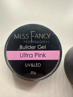 Miss Fancy Builder Gel Ultra Pink - Builder Gel Ultra Pink från Miss Fancy är en professionell nagelgel för UV och LED. Gelen har en snygg, ljusrosa färg och kommer i en rund burk på 50g. Perfekt för att bygga och forma naglar med en naturlig rosa ton. Det är i hög viskositet. Har endast testad och är typ hela burken kvar!