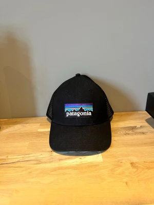 Patagonia keps - Snygg svart Patagonia keps perfekt för kommande årstid och väder. Till säljes för bra pris. Prislapp sitter kvar och kepsen är aldrig använd. Säljs då det inte gick att lämna tillbaks varan. Hör av er om minsta fundering💫
