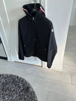 Svart vindjacka från Moncler - Tänkte nu sälja min svarta Moncler windbreaker. Jackan är i Moncler storlek 2 vilket passar dig som har S-M sitter dock mer som en S och därmed säljer jag den som en S. Har använt denna jackan i drygt 2 månader och är i väldigt fint skick, näst intill nyskick. Vid fler fråger eller bilder så är det bara att skriva😀