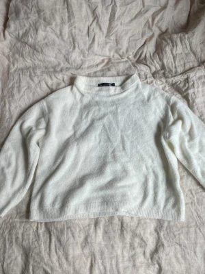 Vit stickad tröja från Lager 157 - Mysig vit stickad tröja från Lager 157 med rund halsringning och ribbade muddar vid ärmslut och nederkant. Tröjan har en enkel och clean design som passar perfekt till alla typer av outfits. Materialet känns mjukt och bekvämt mot huden. Skriv om ni har andra frågor!🥰