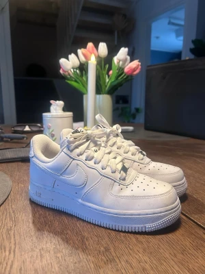 Nike Air Force 1 vita sneakers - Klassiska helvita Nike Air Force 1 sneakers i storlek 36. Använt dem 2 gånger, säljer då de är för stora för mig. Köpt för 1500kr, säljer för 1000kr. Pris kan diskuteras vid snabb affär