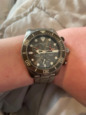 Certina herrklocka i rostfritt stål - Snygg Certina herrklocka med robust länkarmband i rostfritt stål. Klockan har en klassisk rund boett och detaljerade knappar på sidan. Nypris på denna är 11000 kr. Har box till den. Skriv dm till mig om ni är intresserade! 