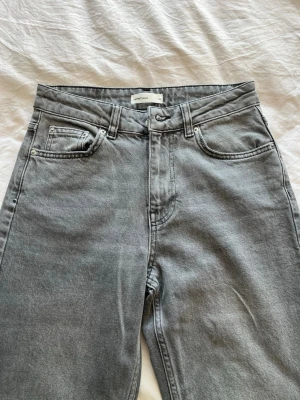 Grå raka jeans från ginatricot  - Snygga grå jeans från Ginatricot med rak passform och klassisk femficksdesign. Jeansen har hög midja.