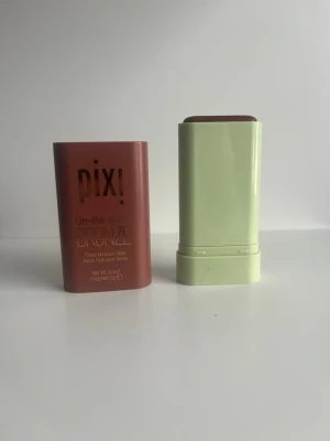 Pixi On-the-Glow Bronze stick - Bronzer i stickformat från Pixi, On-the-Glow Bronze. Färgen är en varm bronzig ton och stiftet har en smidig, rektangulär form med grön botten och brun hylsa. Perfekt för att snabbt ge ansiktet glow och definition. Enkel att applicera direkt på huden.