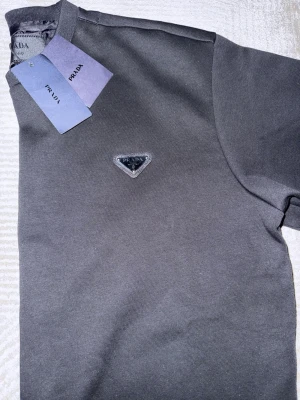 Svart sweatshirt från Prada - Svart sweatshirt från Prada tillverkad i mjukt bomullsmaterial stilren look