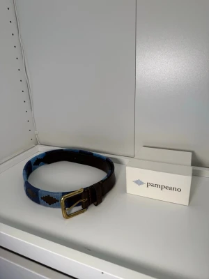Pampeano bälte - Snyggt bälte från Pampeano i skinn med blått och brunt mönster. Hyfsat skick. Box tillkommer. Storlek 90.