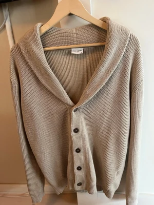 Cardigan från John Henric  - Säljer en beige ribbstickad kofta/cardigan från John Henric i mycket fint skick!