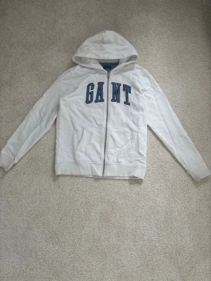Vit hoodie från GANT - Snygg vit ziphoodie från GANT i storlek 158/164. Jättefin och i bra skick.