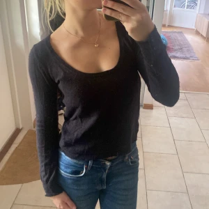 Svart stickad tröja med rund hals - En svart långärmad tröja från Zara med rund, djup urringning och långa ärmar. Tröjan har en enkel och stilren design som passar perfekt till jeans eller kjol. Mjuk och skön att bära. 