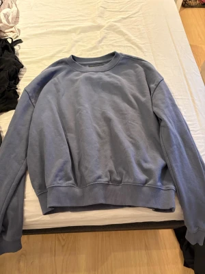 Blå sweatshirt - Jag säljer en mörkblå sweatshirt. Med ribbade kanter vid händerna, halsen och vid slutet av magen