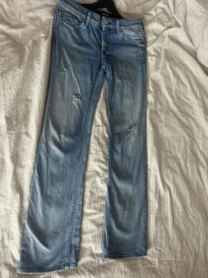 Ljusblå bootcut jeans med slitningar - Bootcut Replay jeans blå. Waist 28 length 32. Välanvända men fotfarande fint skick.