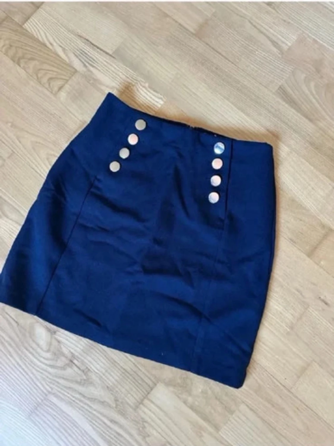 Mörkblå kjol med silvriga knappar