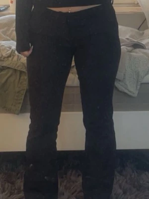 Svarta kostymbyxor - Säljer trendiga kostymbyxor från bikbok med låg midja. Byxorna har en snygg passform som sitter tajt över låren och släpper ut vid vaden. Perfekta för dig som gillar en stilren och trendig look.